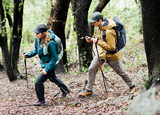 Man and woman hiking through a forest using Black Diamond Pursuit Trekking Poles